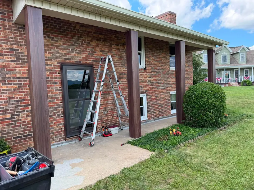 New white seamless gutters on a brick home with a covered porch