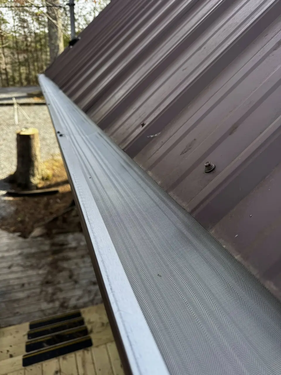 Gutter guard installed under a metal roof